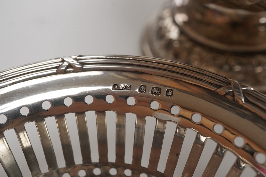 A George III small silver sugar basket, London, 1810, with blue glass liner, 57mm, a George III silver sifter spoon, a pair of silver bonbon dishes and an Edwardian small rose bowl, 16.9oz. Condition - poor to fair to go